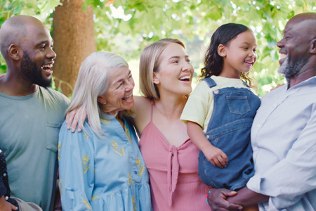 Diverse family outside enjoying the air and each other.